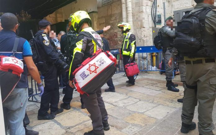Ambulancefolk og politi på stedet, hvor en politimand blev stukket ned d. 15 august. (Foto Magen David Adom)